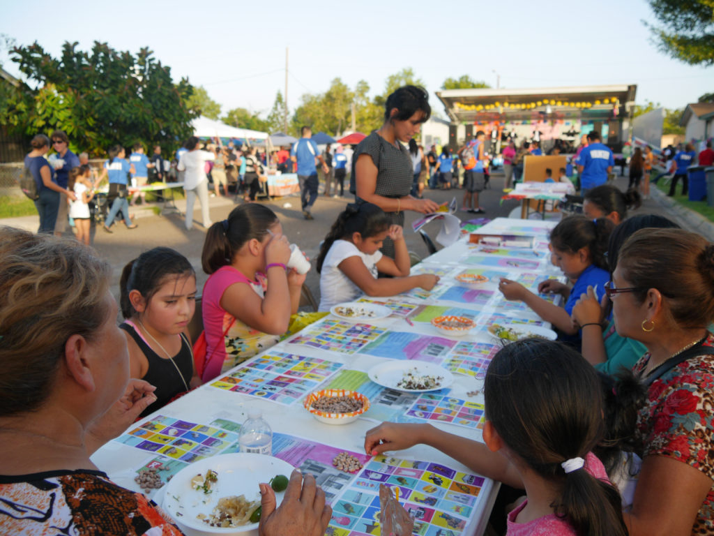 Brownsville Lóteria, 2016. Participants playing Brownsville Lóteria (Mexican Bingo) and making their cards for play. The game substituted iconic Lóteria imagery with images specific to the region, placing a heavy emphasis on civic art. Attendees were also invited to make their own cards by reflecting on the images, places and things that they think define the city. Participant responses ranged from memorable water fountains to their personal living room. Project concept developed as part of Activating Vacancy Arts Incubator in collaboration with buildingcommunityWORKSHOP. Image: buildingcommunityWORKSHOP.