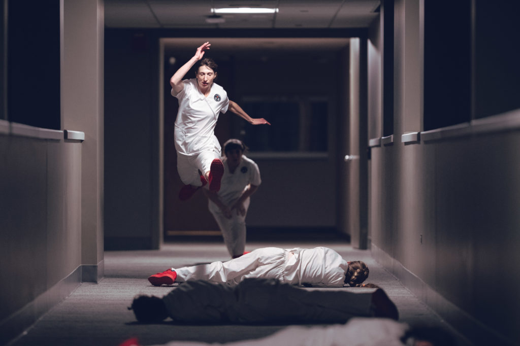 First, Do No Harm Bridge Dance: Performer Tara Rynders running through the halls exploring the exhaustion, grief, and compassion fatigue that arises in the complicated roles nurses play with patients, doctors and other nurses. Photo by DW Burnett.