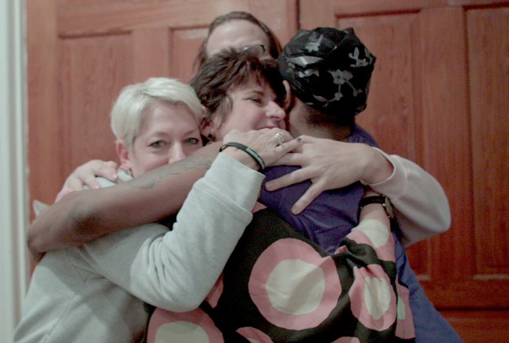 Mama bears Sara Cunningham, Laura Beth Taylor and Susan Cottrell share a hug with a resident of Philadelphia’s Home for Hope shelter for LGBTQ people, photo courtesy the artist.